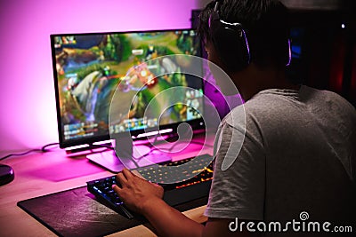 Photo of teenage gamer boy playing video games on computer in da Stock Photo