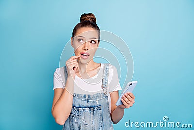 Photo of thinking pondering pensive planning charming cute girl holding phone with hand contemplating something while Stock Photo