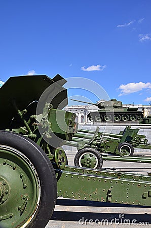 Photo of three guns of the Soviet Union of the Second World War against the background of the green tank T-3 Editorial Stock Photo