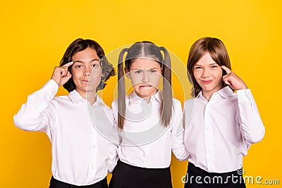 Photo of three minded schoolchildren hard brainstorming wear white shirt isolated yellow color background Stock Photo