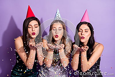 Photo of three romantic ladies blow air kiss confetti wear cone cap dresses isolated violet color background Stock Photo