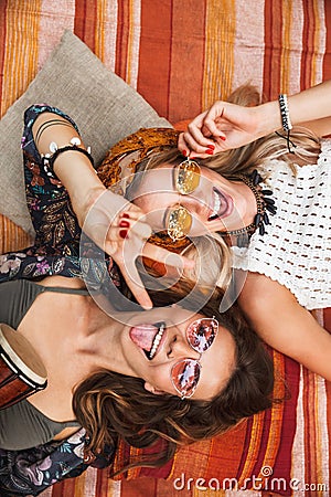 Photo from top of two young hippie girls, smiling and lying on b Stock Photo