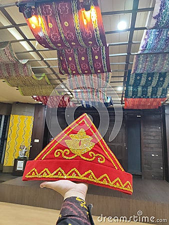 Photo of a traditional Malay banjar hat with an exotic Sasirangan cloth as a background in a historic house Stock Photo