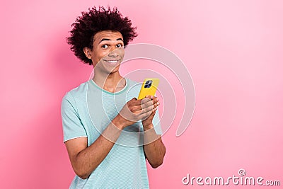 Photo of tricky excited man dressed blue t-shirt chatting instagram twitter telegram facebook empty space isolated pink Stock Photo