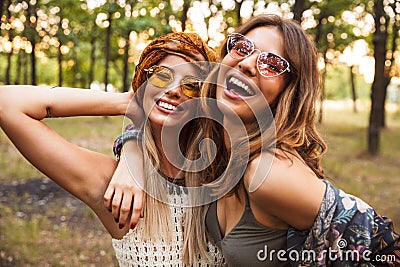 Photo of two young hippie girls, smiling and hugging each other Stock Photo