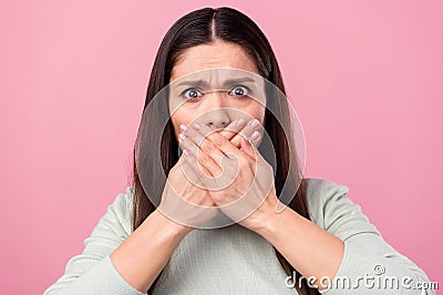 Photo of unhappy scared young woman cover close hands face tell secret isolated on pink color background Stock Photo