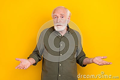 Photo of unsure aged grey hairdo man shrug shoulders wear khaki outfit isolated on yellow color background Stock Photo