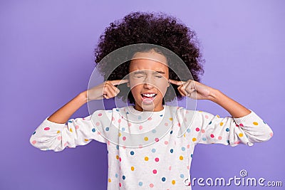 Photo of upset afro american girl close ears fingers loud noise wear white dotted jumper isolated on violet color Stock Photo