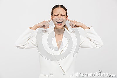 Photo of uptight nervous businesswoman 20s wearing elegant jacket screaming and plugging ears with fingers Stock Photo