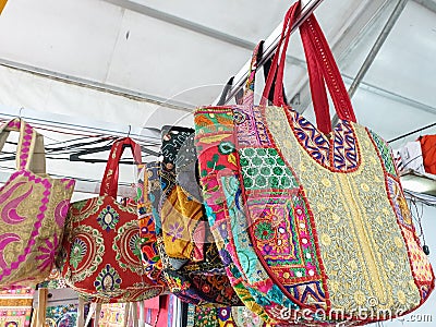 Photo of variety of colorful Rajasthani artwork handbags hanging in the store for sale Editorial Stock Photo