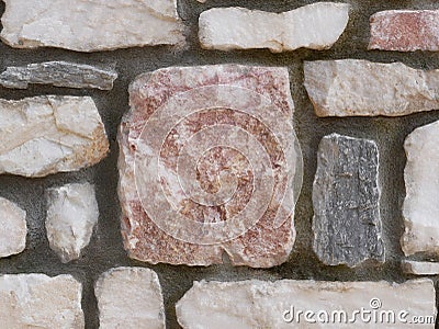 Photo A wall built of square and rectangular marble pieces of different sizes and cement. Stock Photo