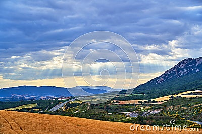 Colorful hills hit by sunrays filtering through the clouds in Navarra, Spain Stock Photo