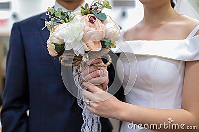 Photo of wedding bouquet in hands of groom and bride. Stock Photo