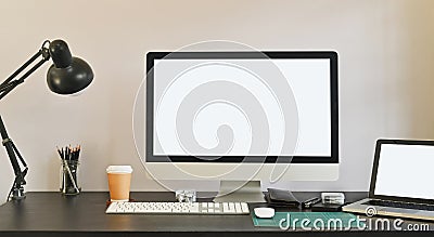 Photo of white blank screen computer and white blank screen laptop putting on the table together including lamp and coffee cup. Stock Photo