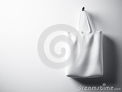 Photo white cotton textile bag hanging right side. Empty concrete wall background. Highly detailed texture, space for advertising. Stock Photo