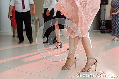 photo of woman legs in stylish high hell shoes on floor dancing at a wedding party Stock Photo