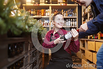 Photo of woman seller with bottle of wine and buyer Stock Photo