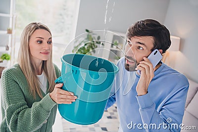 Photo of worried spouses lady guy have apartment trouble water drops falling from ceiling call plumber smartphone Stock Photo