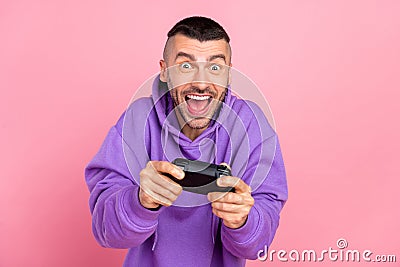 Photo of young addicted crazy man play console game joystick race isolated over pink color background Stock Photo