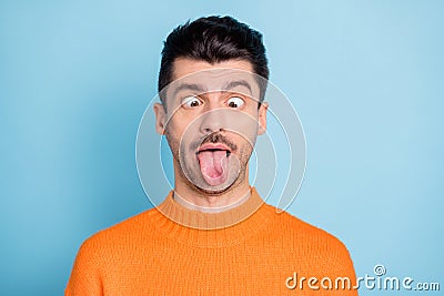 Photo of young brown hair man fooling grimacing joke humor comic tongue-out isolated over blue color background Stock Photo