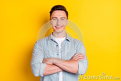 Photo of young cool confident smiling charismatic businessman with folded hands isolated on yellow bright background Stock Photo