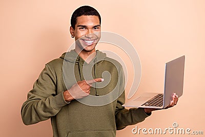 Photo of young it developer positive mood man wear khaki trendy sweatshirt hold laptop direct finger vacancy job Stock Photo