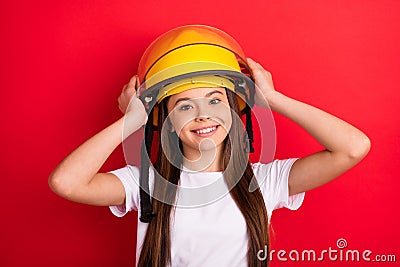 Photo of young girl happy positive smile hands touch helmet firewoman isolated over red color background Stock Photo