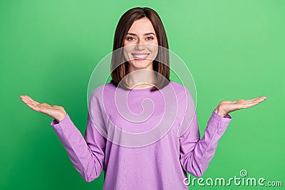 Photo of young happy attractive lady hold two hands compare products low price high quality smiling isolated on green Stock Photo
