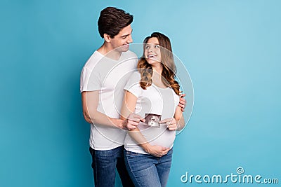 Photo of young happy excited positive smiling family hold ultrasound picture of baby isolated on blue color background Stock Photo
