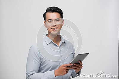 Photo of young happy man standing over white background using tablet computer Stock Photo