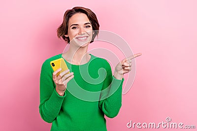 Photo of young internet user woman hold gadget directing finger empty space virtual reality advertisement isolated on Stock Photo