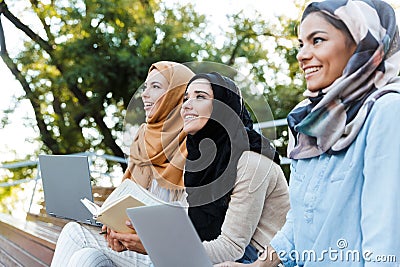 Photo of young muslim girls wearing headscarfs resting in green park Stock Photo