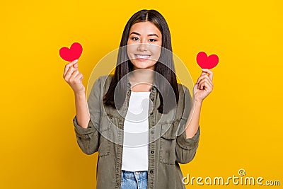 Photo of young smiling vietnamese girl wear khaki trendy shirt brunette hair hold red love symbols valentine day Stock Photo