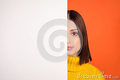 Photo of young woman close half-face placard white wall advertise news information isolated over orange color background Stock Photo