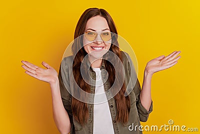 Photo of young woman shrug shoulders isolated over yellow background Stock Photo