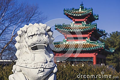 A Lion Statue Keeps Watch over an Asian-Style Building at Robert D. Ray Asian Gardens in Des Moines, Iowa Stock Photo