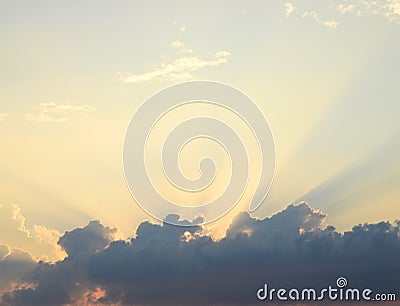 Golden Yellow Crepuscular Sun Beams from Dark Clouds in Bright Sky - Natural Background Skyscape Stock Photo