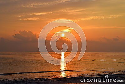 Golden Sun Rising at Horizon with Warm Colors in Sky with Reflection in Sea Water - Kalapathar Beach, Havelock Island, Andaman Stock Photo