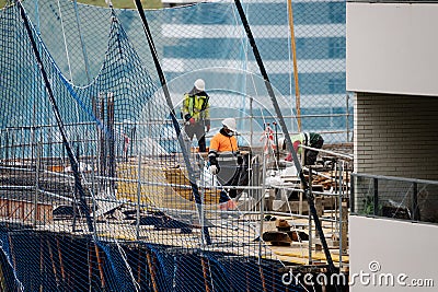 Photograph of a group of workers working in construction with masks during the covid-19 pandemicPhotograph of a group of workers Editorial Stock Photo