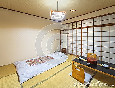 Japanese-style bedroom with tatami mats, shoji doors, fusuma walls and a futon mattress. Stock Photo