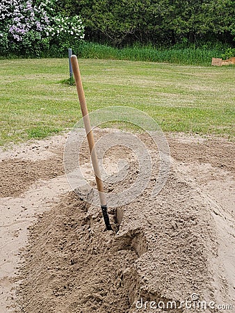 A photograph of a shovel in a pile of construction sand Stock Photo