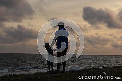 Photograph of a son and father enjoying the sun set good for fathers day celebration Editorial Stock Photo