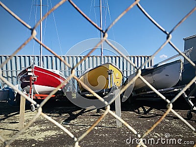 Photograph three different yachts through wire fence. Stock Photo