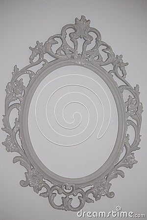 Photograph of white rococo frame hanging on wall Stock Photo