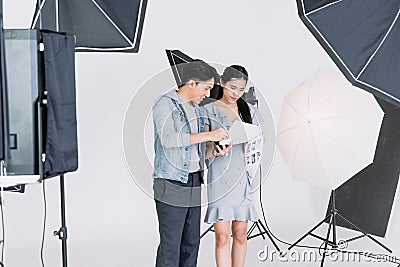 An Asian photographer is introducing poses to young Asian models. By opening preview of posting in the document Stock Photo