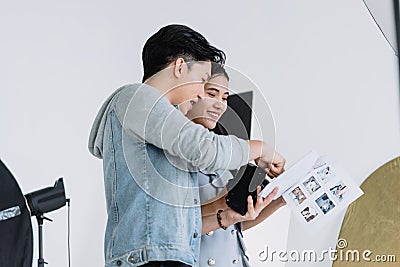 An Asian photographer is introducing poses to young Asian models. By opening preview of posting in the document Stock Photo