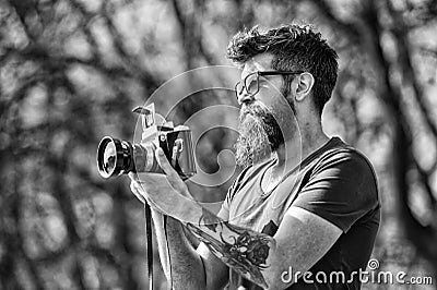 Photographer with beard and mustache amateur photographer nature background. Man with long beard busy with shooting Stock Photo