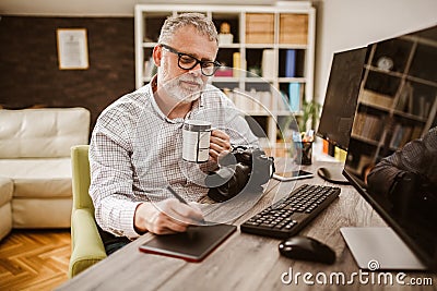 Photographer with beard, while working in his office at home Stock Photo