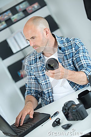 photographer checking how to clean camera online Stock Photo