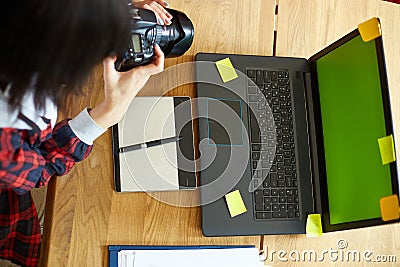 Photographer female working in a creative office holding camera, at desk and retouch photo Stock Photo